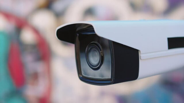 Shot of security camera moving recording outside a building. CCTV surveillance. Privacy, urban, protection, house, system, control, secure, view, safe, video. Slow motion