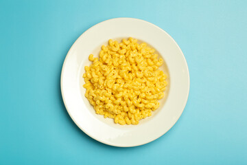 Pasta background. Mac and Cheese pasta on a blue background. American style Italian pasta with cheese.