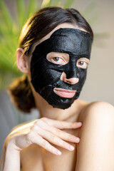 Portrait of a woman in black cleansing mask