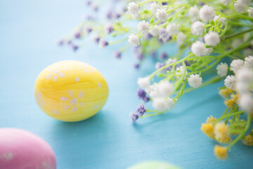 Easter eggs decoration with flowers on blue wooden table