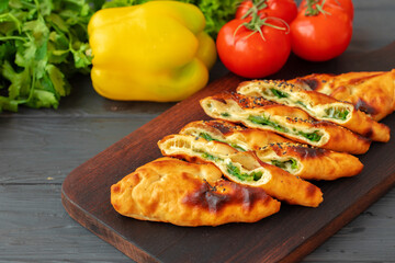 Stuffed bread, turkish pie with herbs on wooden board