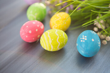 Colorful easter decoration with and flowers on gray wooden table. Top view