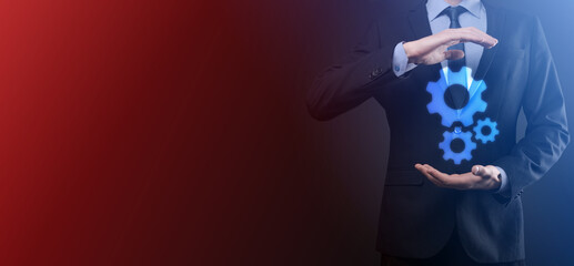 Business man in suit holding metal gears and cogwheels mechanism representing interaction teamwork concept,hand hold group of virtual cog gears wheel.