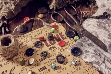 Sewing thread scissors buttons for seamstress on wooden background.