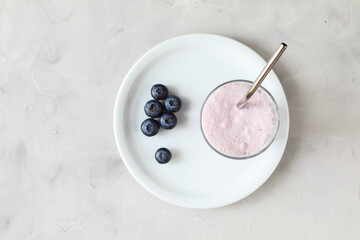 Fresh and delicious blueberry milkshake with blueberry berries on the plate for proper nutrition for breakfast
