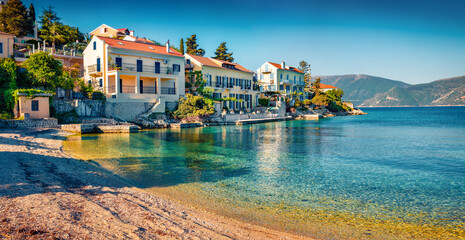 Fototapeta premium Beautiful marine scenery. Bright summer cityscape of Fiskardo town with Zavalata Beach. Stunning morning seascape of Ionian Sea. Wonderful outdoor scene of Kefalonia island, Greece, Europe.