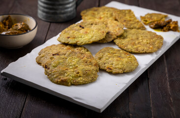 crispy and salty mathri with mango pickle on a white tray