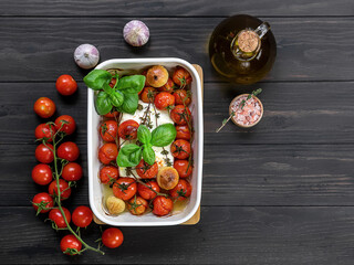 Baked feta cheese with tomatoes, capers, garlic, herbs, and olive oil. In the oven it turns into an amazing sauce by itself. Just add some cooked pasta, mix, and enjoy. viral trendy recipe.