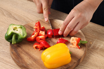 Chef chopped bell pepper on wooden cutting board