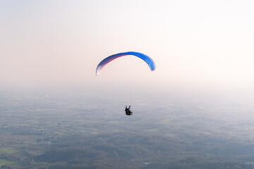 Paragliding at sunset over the mountains, Italy