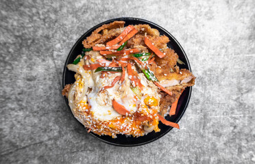 Japanese food, Katsu Don is breaded deep-fried pork and eggs cooked in a sweet and salty served over rice.