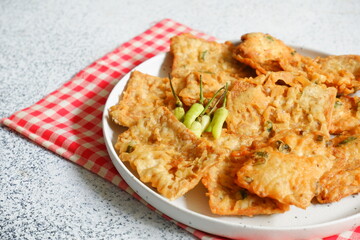 a plate of fried crispy tempeh served with fresh chili 