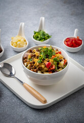 black gram or kala chana chaat with boiled potato, onion, tomato with a dash of lemon juice served on a white bowl