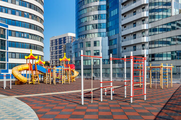 Children grounds for playing and sport exercises among new modern high-rise city buildings. Urbanized environment without lawns and trees