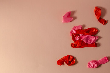 Minimalistic composition with deflated balloons on a pink backgr