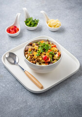 black gram or kala chana chaat with boiled potato, onion, tomato with a dash of lemon juice served on a white bowl