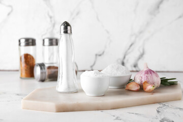 Composition with salt and garlic on light background