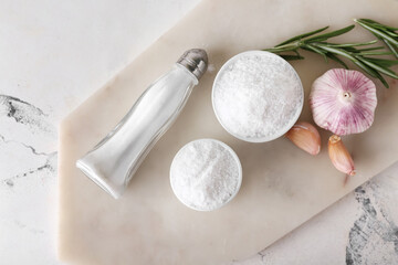 Saltcellar and bowls of salt on light background