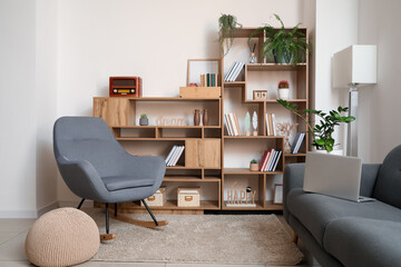 Interior of modern room with shelf units, sofa and armchair