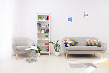 Interior of modern living room with shelf unit, sofa and armchair