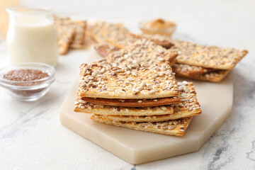 Tasty crackers with seeds on light background