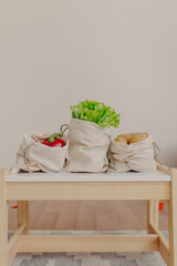Fototapeta na wymiar Reusable storage bags with lettuce, potatoes, red pepper on white table. Healthy food on white background.