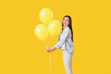 Beautiful young woman with balloons on color background