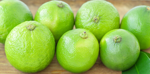 Green limes on wooden background