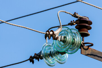Electric pole against the blue clear sky. Three-phase power line to turn