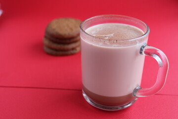 Cocoa hot chocolate in a glass mug on a red background with room for text copyspace and liver on hellish plan