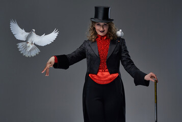 Woman in old fashioned costume with two pigeons and stick in studio
