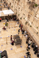 Obraz premium Jews pray on the women side of the Western Wall. View from the stairs leading to the Maghreb Gate of the Temple Mount, near the Western Wall, in the old city of Jerusalem, Israel