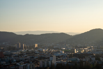 Sonne strahlt über die Stadt Graz mit Bergen im Hintergrund