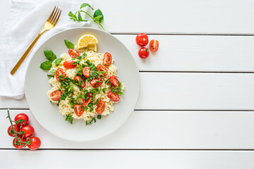 Fresh home-made tabouli, or tabbouleh salad, top view on white wooden background with copy space