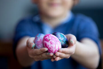 Sweet children, brothers, coloring and paiting eggs for Easter in garden, outdoor at home in backyard