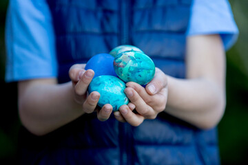 Child, holding colored eggs in garden