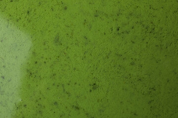 Fresh green smoothie on whole background, close up