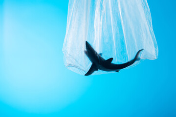 Environmental and ocean pollution concept, shark toy in plastic bag