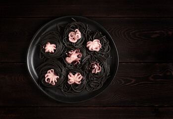 Black pasta, with baby octopus, dish, on a black wooden background, top view, no people, 