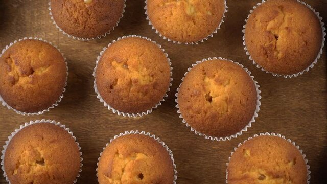 Muffins - delicious pastries. Baked dessert on the tabletop view. Homemade muffin. Portioned cupcakes. Simple food for party. Close-up muffins on a wooden tray.