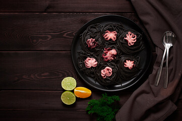 Black pasta, with baby octopus, dish, on a black wooden background, top view, no people, 