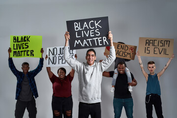 Young gypsy man holding poster with anti racist quote