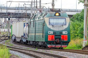 Obraz premium The freight train passes by the station. Wagons with goods delivery.