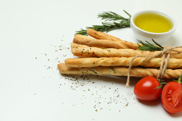 Grissini breadsticks with spices on white background