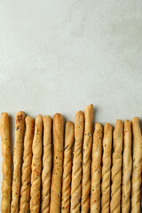 Tasty grissini breadsticks on white textured background
