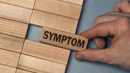 Symptom word concept. Close-up wooden piece blocks on the table