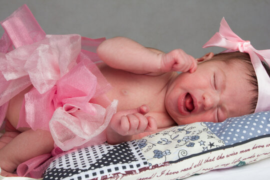 photo of a baby girl in a pink skirt and bow.