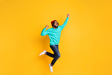 Fototapeta na wymiar Full size profile photo of brunette optimistic guy jump wear cap spectacles pullover jeans sneakers isolated on yellow color background