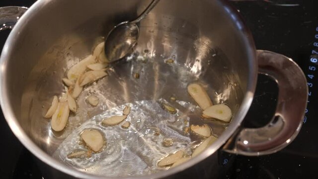 Cook roasts garlic in a saucepan