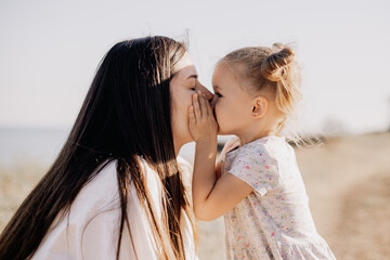 a close and sensual portrait of a daughter and mother embracing and basking in the evening sun....